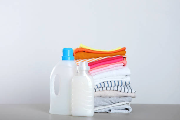 istock Laundry detergent bottles and clothes on the table. Household chemicals 1286530827
