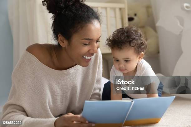 Smiling Biracial Mom Read Book With Baby Infant Stock Photo - Download Image Now - Reading, Baby - Human Age, Book