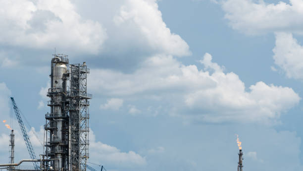 istock Distillation tower or column on blue sky with clouds background. Oil refinery plant. Refining complex. Petrochemical industry concept. 1286532288