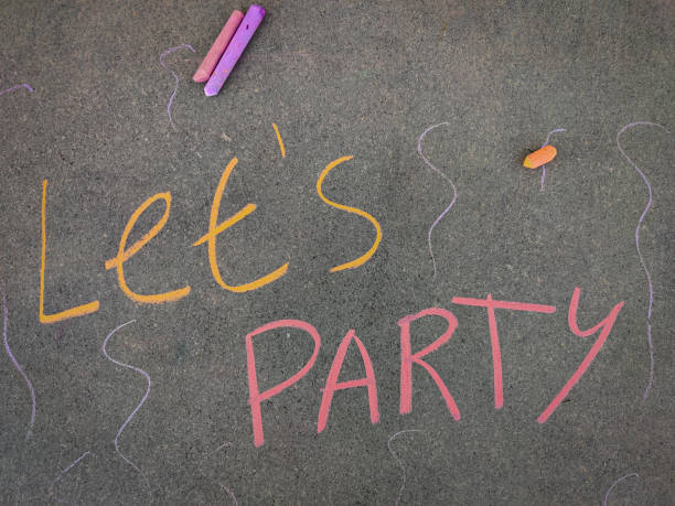 istock The inscription text on the grey board, Let's party. Using color chalk pieces. 1286533398
