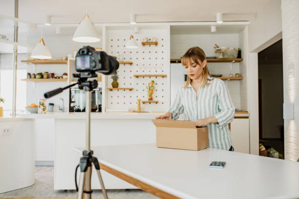 istock Young woman is vlogging about unpacking the package she ordered online 1286533679