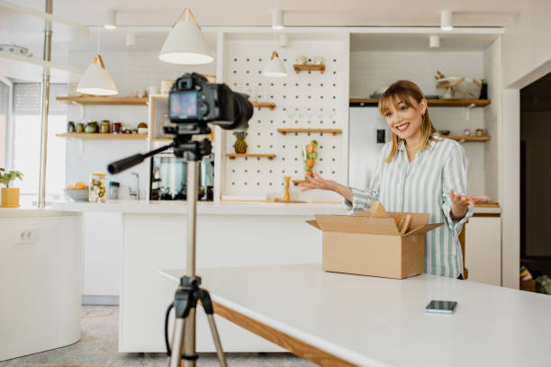 istock Young woman is vlogging about unpacking the package she ordered online 1286533780