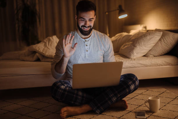 istock Young man making a video call on his laptop at home at night 1286533917