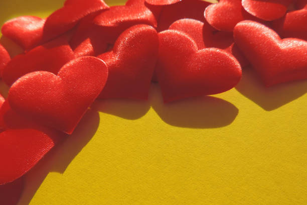 istock red hearts on  dark yellow textured cardboard surface , Valentine Hearts with hard shadows, copy space 1286534973