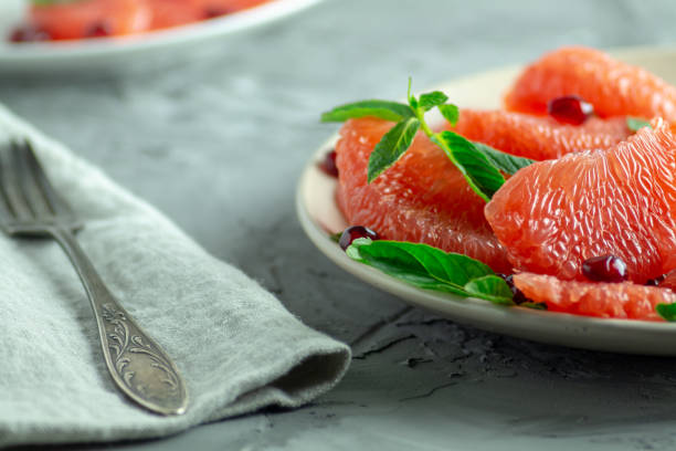 istock Grapefruit slices with mint and pomegranate leaves. 1286536461