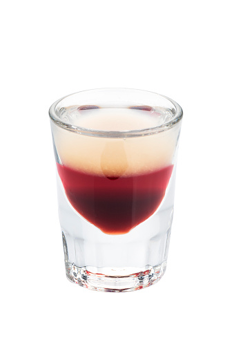 Alcohol shots cocktail in a glass isolated on white background. Layered composed of white and red liqueur