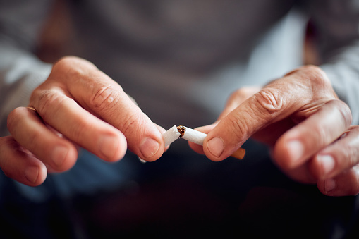 the harm of Smoking, a broken cigarette in a man's hands