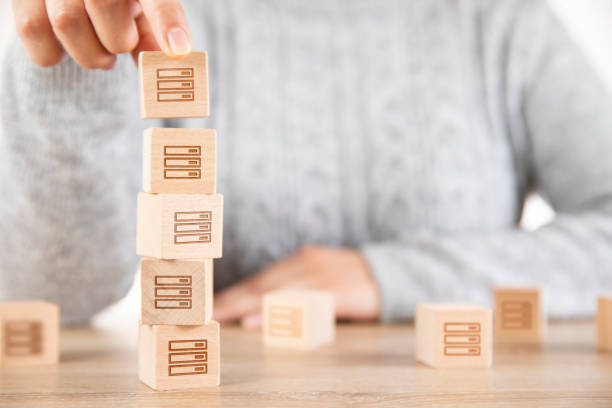 istock Woman is Stacking Wooden Cubes with Data Symbols 1286539945