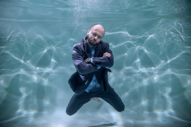 istock Young businessman folded his hands and sternly looks at camera underwater 1286540529