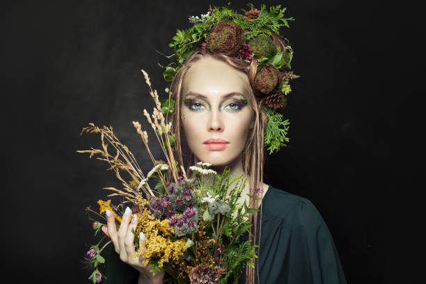 istock Nymph woman with wild flowers on black background 1286543718