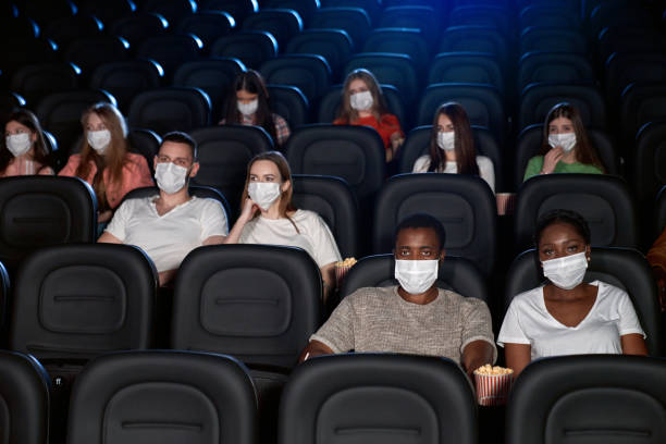 istock Audience wearing face masks enjoying time in cinema. 1286544961
