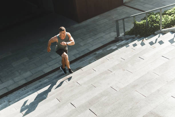 istock Muscular man is running upstairs by concrete staircase 1286546346