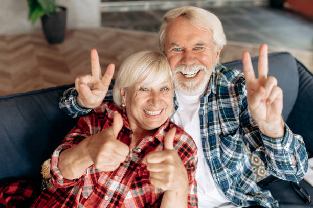 istock Cheerful elderly caucasian couple looking at camera smiling and showing hands gestures 1286546450