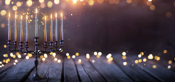 hanukkah abstract defocused background - menorah with bright dust on wooden table - candle hanukkah menorah candlelight imagens e fotografias de stock