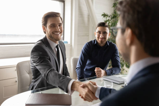 istock Smiling businessmen shaking hands, establishing partnership. 1286549414