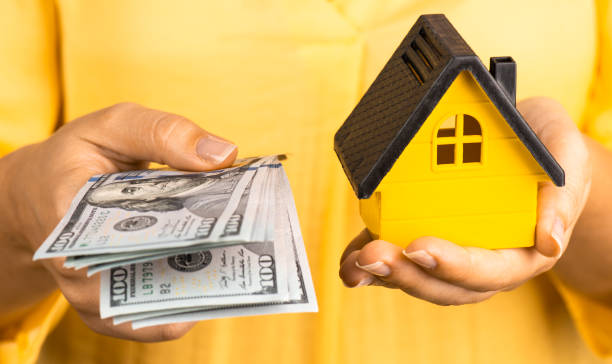 woman holding dollars and model house - Bankruptcy - Your Home Equity Could Save You