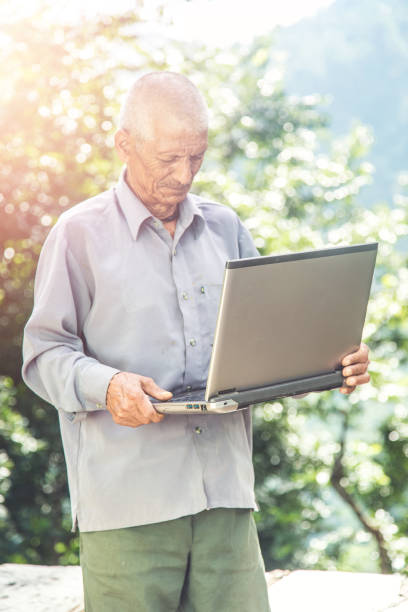 istock Old village Indian man holding laptop 1286550761