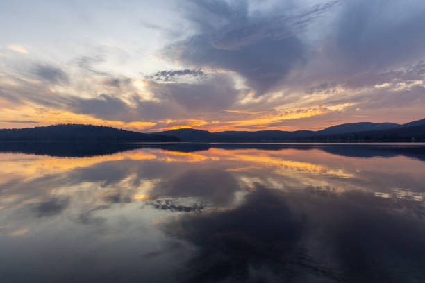 View of Lac St-Joseph, Fossambault Sur Le Lac, Quebec, Canada at Sunset. The lake is a perfect mirror and there is an incredible sunset.