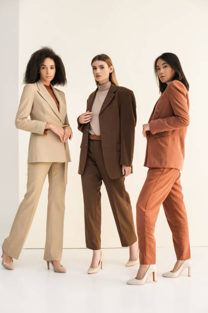 istock full length of trendy interracial models in suits posing on white 1286551018