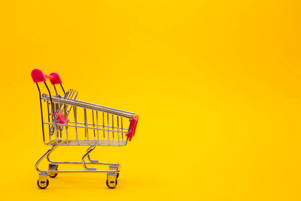 istock Empty shopping cart on yellow background. 1286551158