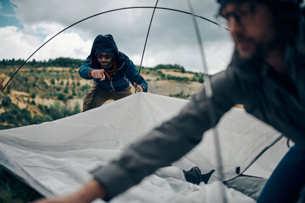 istock Two men adjusting tent on camping trip. 1286556286