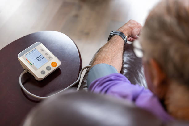 Senior Man checking blood pressure on Auto blood pressure Machine at home Senior Man checking blood pressure on Auto blood pressure Machine at home pressure gauge stock pictures, royalty-free photos & images
