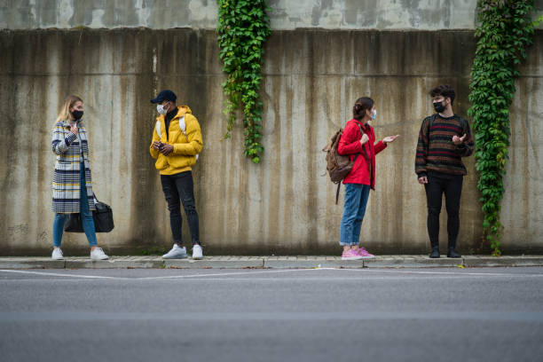 istock Young people talking outdoors in town. Coronavirus and safe distance concept. 1286557972