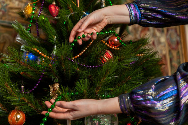 istock Hands hang garland on Christmas tree close up 1286557990