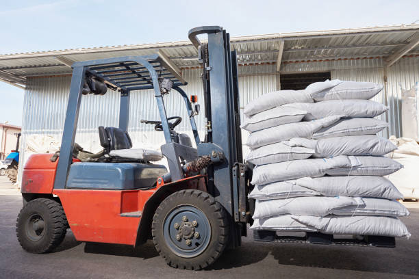 istock Red forklift lifts pallet with white bags 1286558438