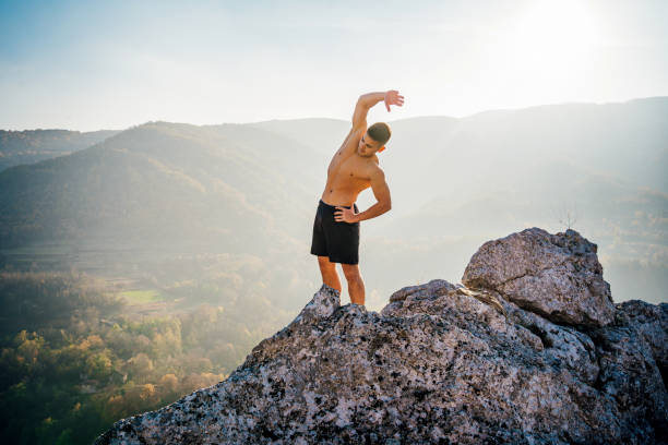 istock Young man stretching on the mountain 1286558653
