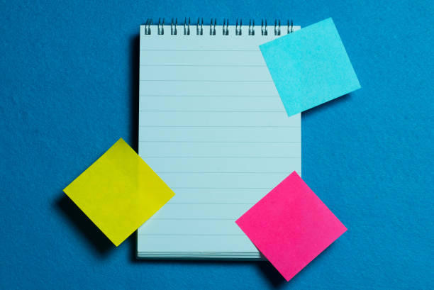 istock blank page of notebook and colorful post it on light blue background 1286559019