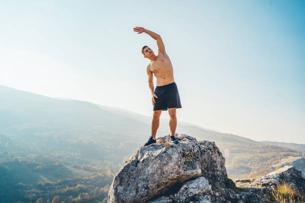 istock Young man stretching on the mountain 1286559640