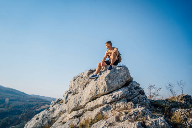istock Man sitting at the top of mountain and looking at view 1286559794