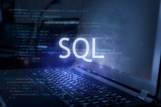 Photo of SQL inscription against laptop and code background. Learn sql programming language, computer courses, training.