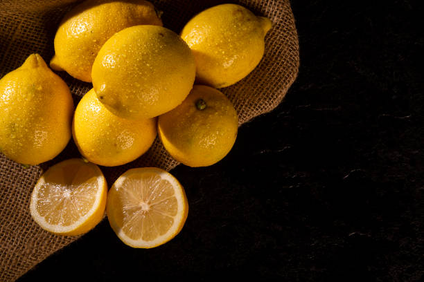 istock Yellow lemons on wooden background 1286562953