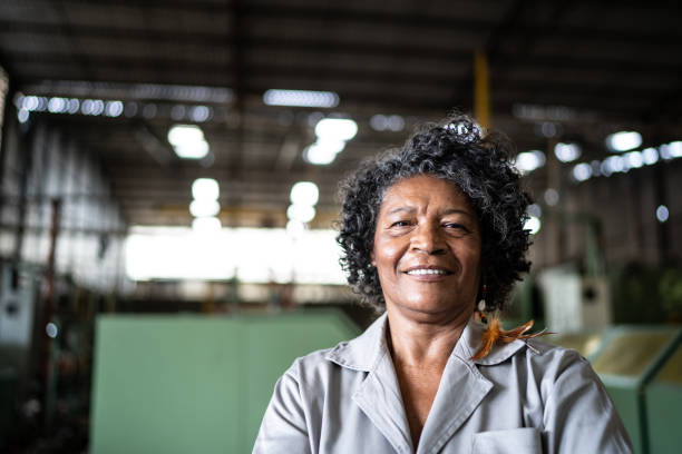 porträt einer seniorin, die in einer branche arbeitet - industriearbeiter stock-fotos und bilder