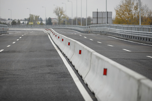 Shallow depth of field (selective focus) image with concrete Jersey barriers (Jersey walls or Jersey bumps) on a highway.