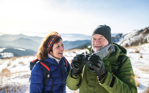 istock Senior couple hikers using binoculars in snow-covered winter nature. 1286567259