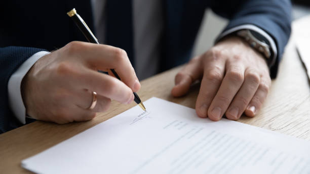 istock Close up young entrepreneur signing paper contract. 1286567813