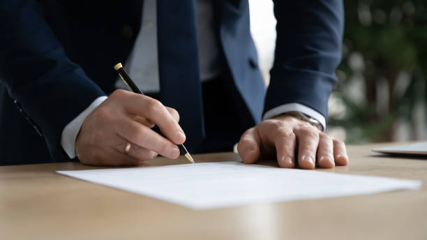 istock Close up young businessman ready signing profitable offer agreement. 1286567820