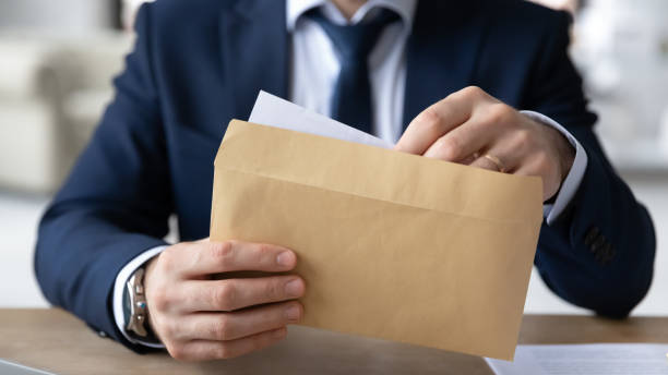 istock Close up young businessman opening envelope with paperwork correspondence. 1286567851