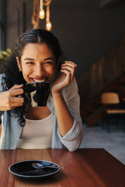 istock Smiling female drinking coffee in cafe 1286569150