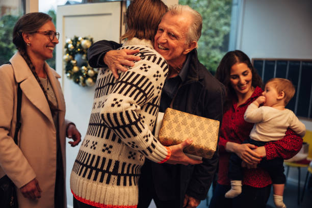 istock Man welcoming family at doorway 1286570632