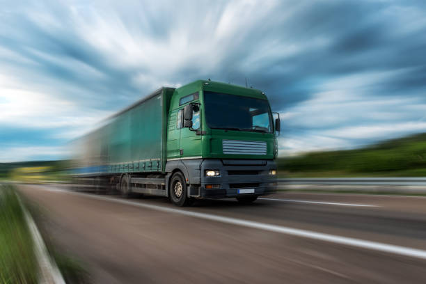 istock Green Lorry truck speeding on freeway at sunset 1286572014