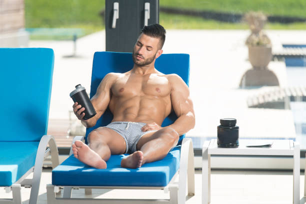 istock Athlete Resting on Lounger With Supplements and Shaker 1286572256