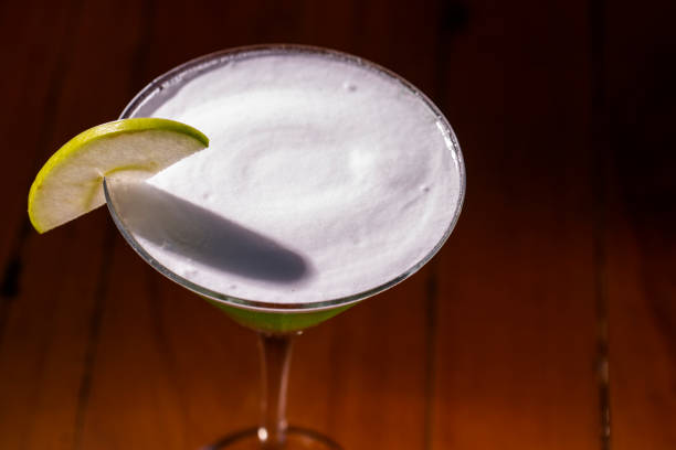 istock Apple Martini mixed drink with apple slice garnish on wood background 1286573561