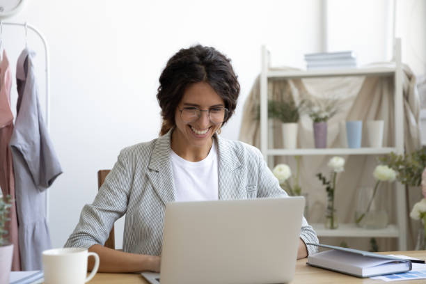 istock Smiling Caucasian woman sit at desk working on laptop 1286575922