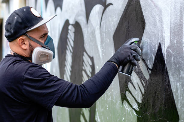 istock Graffiti artist painting on the wall. 1286576015