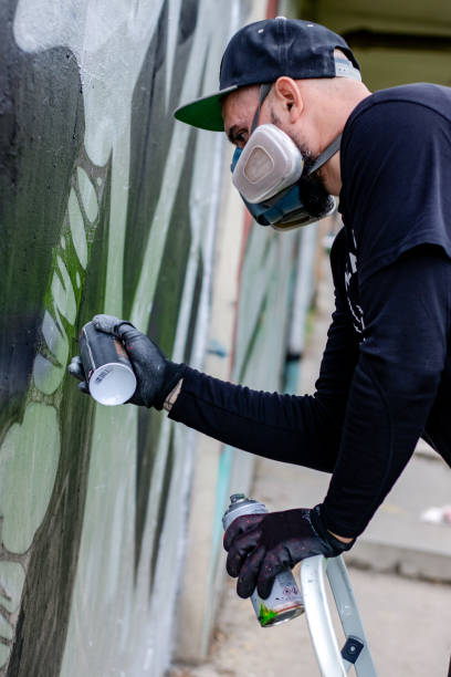 istock Graffiti artist painting on the wall. 1286576053