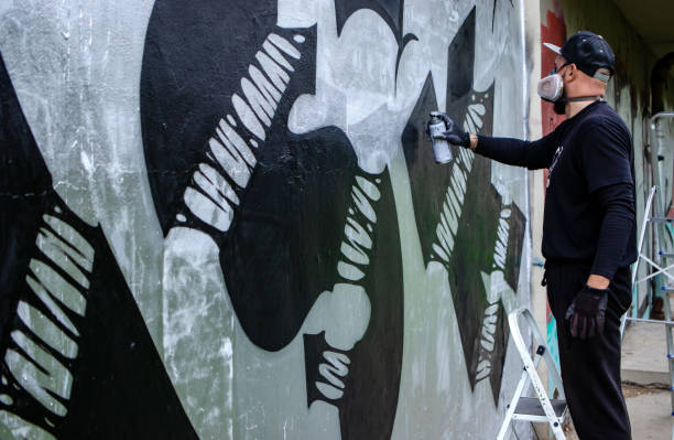 istock Graffiti artist in action, standing on ladders. 1286576093